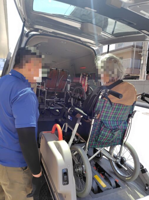 車いすのまま介護タクシーに乗り込むところ