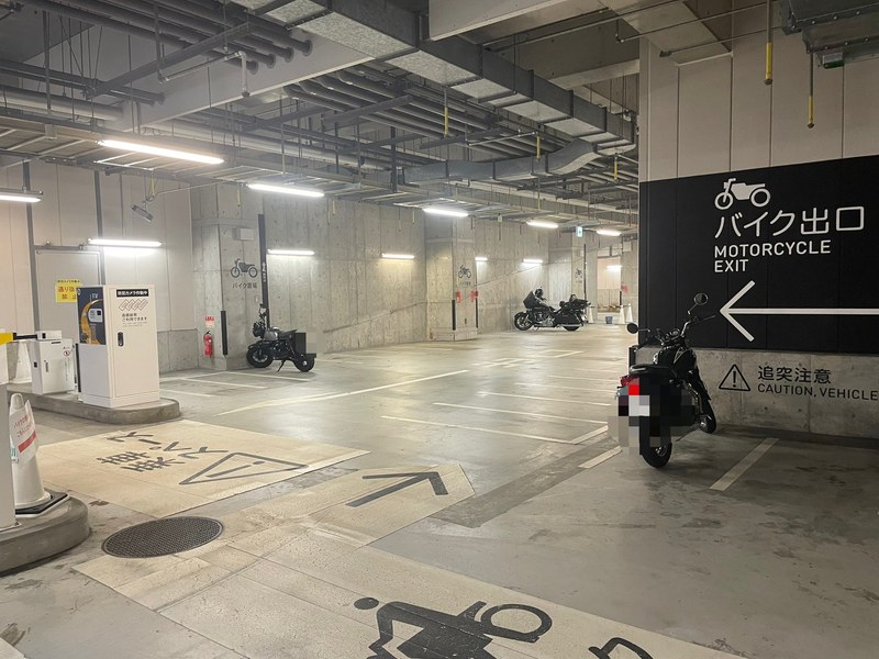 北館のバイク置き場と「バイク出口」の看板